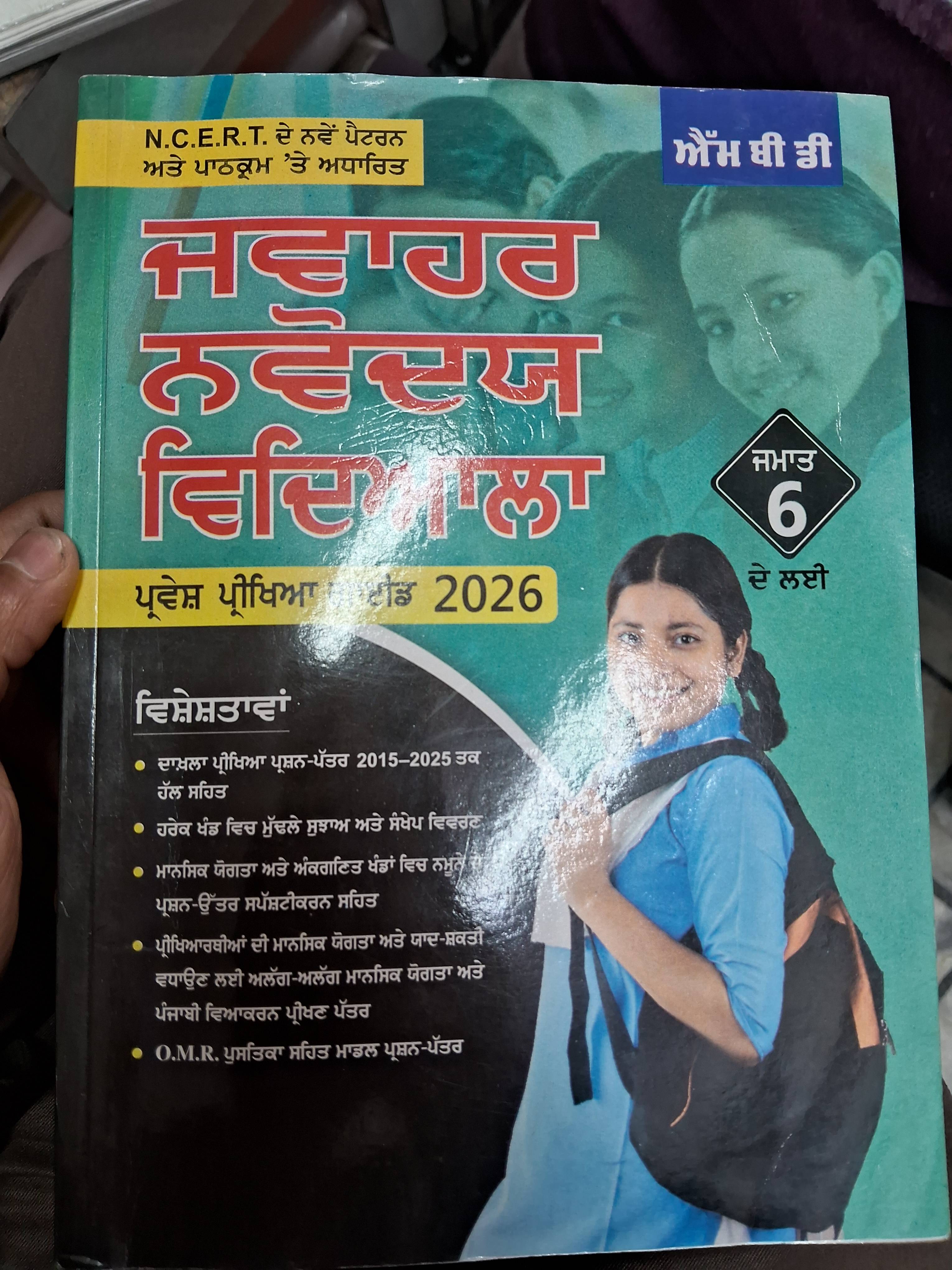 Jwahar Navodya Vidalaya book featuring a colorful cover and educational content displayed on a wooden table in PATRAN.