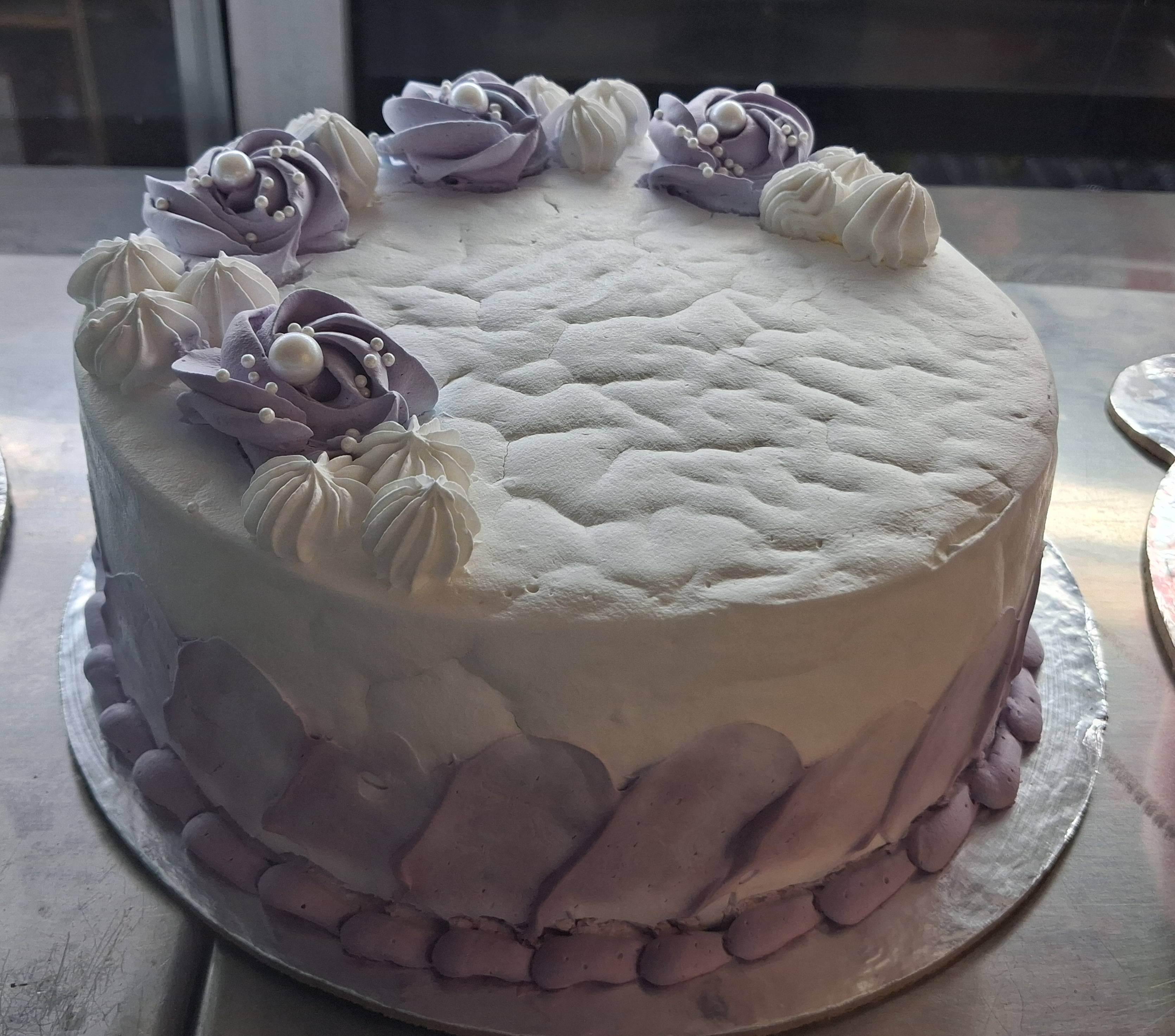 Deliciously layered cake with frosting and decorative elements, freshly baked at KAPOORS in Dharamshala, showcasing its rich 