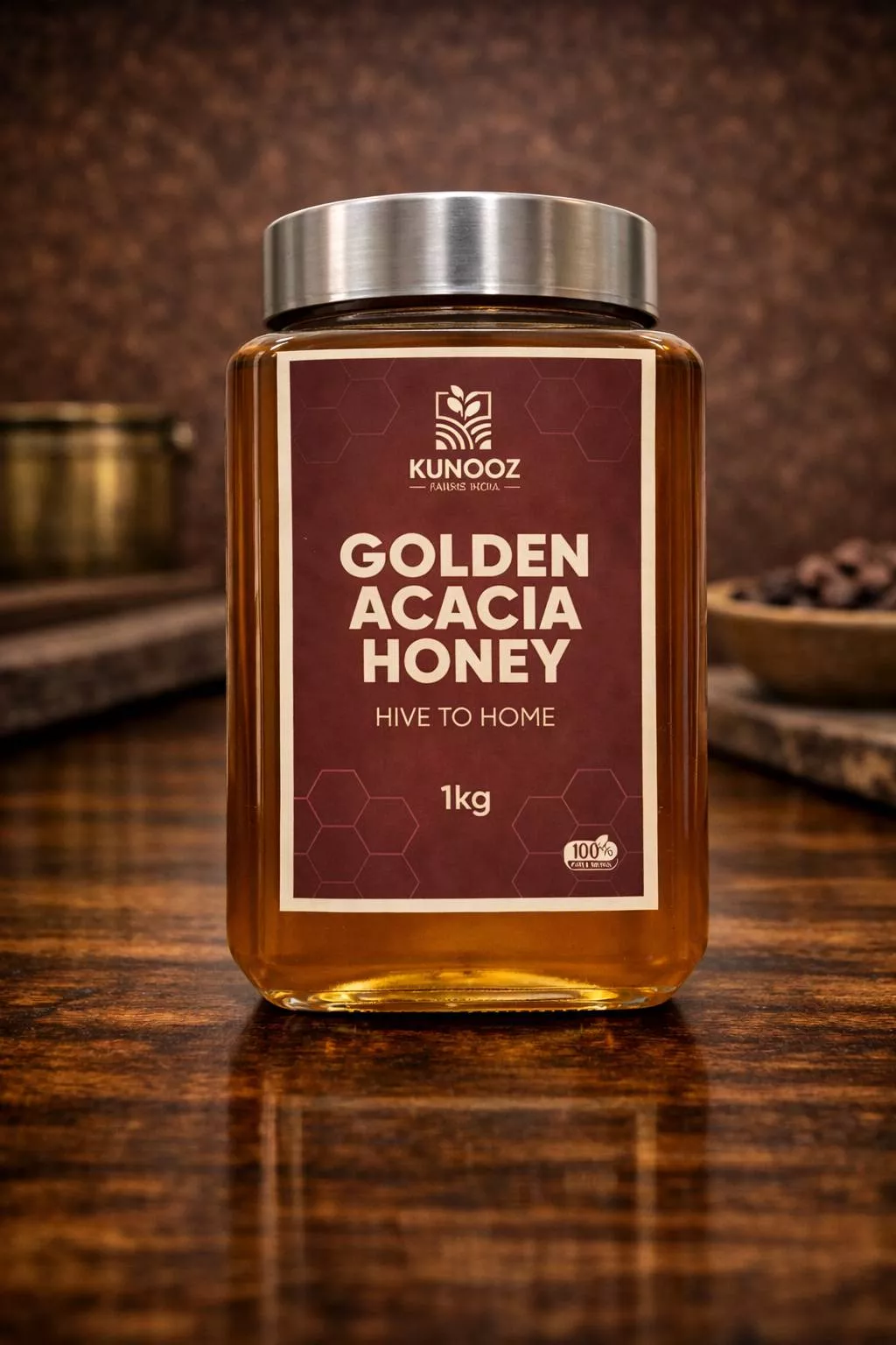Golden amber-colored Kunooz Golden Acacia Honey jar with a natural wooden dipper on a rustic wooden table in Hyderabad.