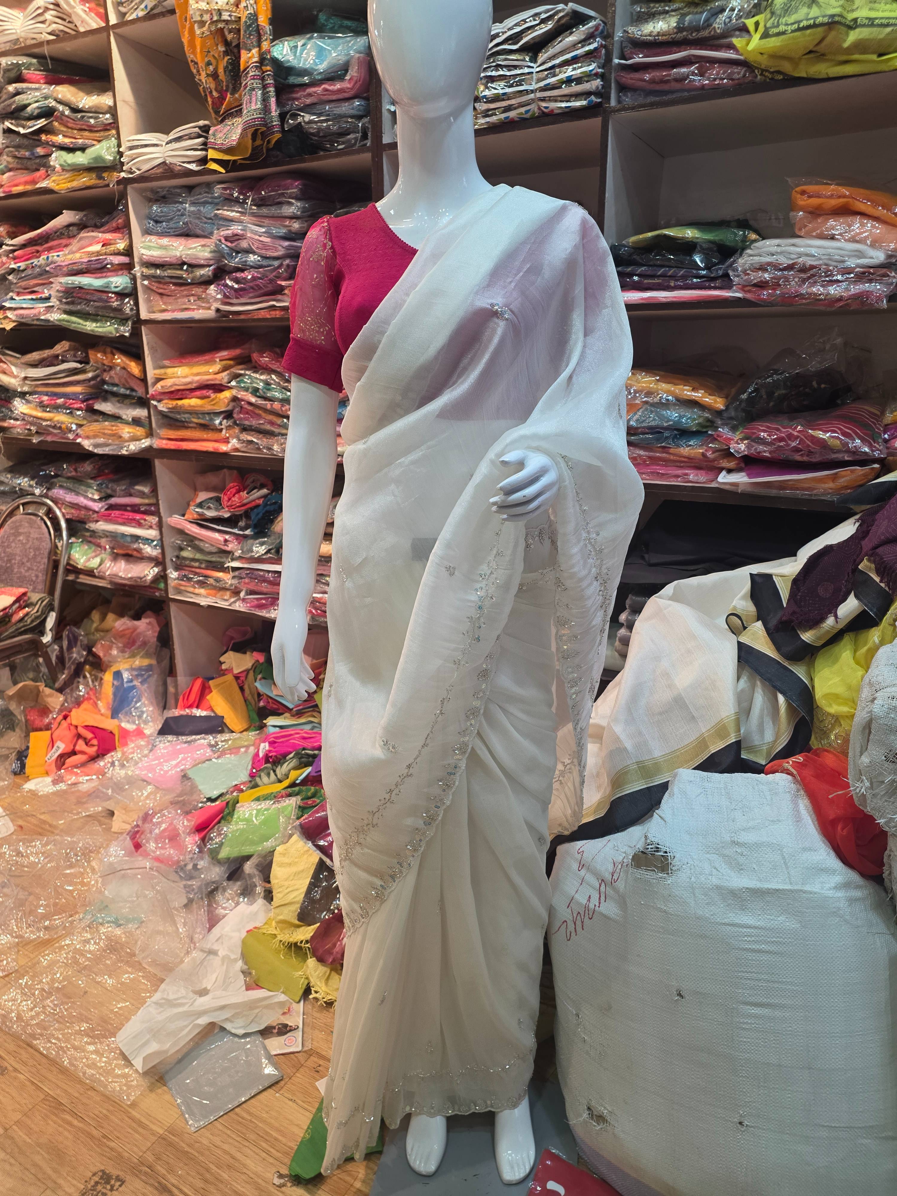 Elegant white embroidered saree with intricate details, showcasing a graceful look, available at RADHA RANI SAREE in Alote.