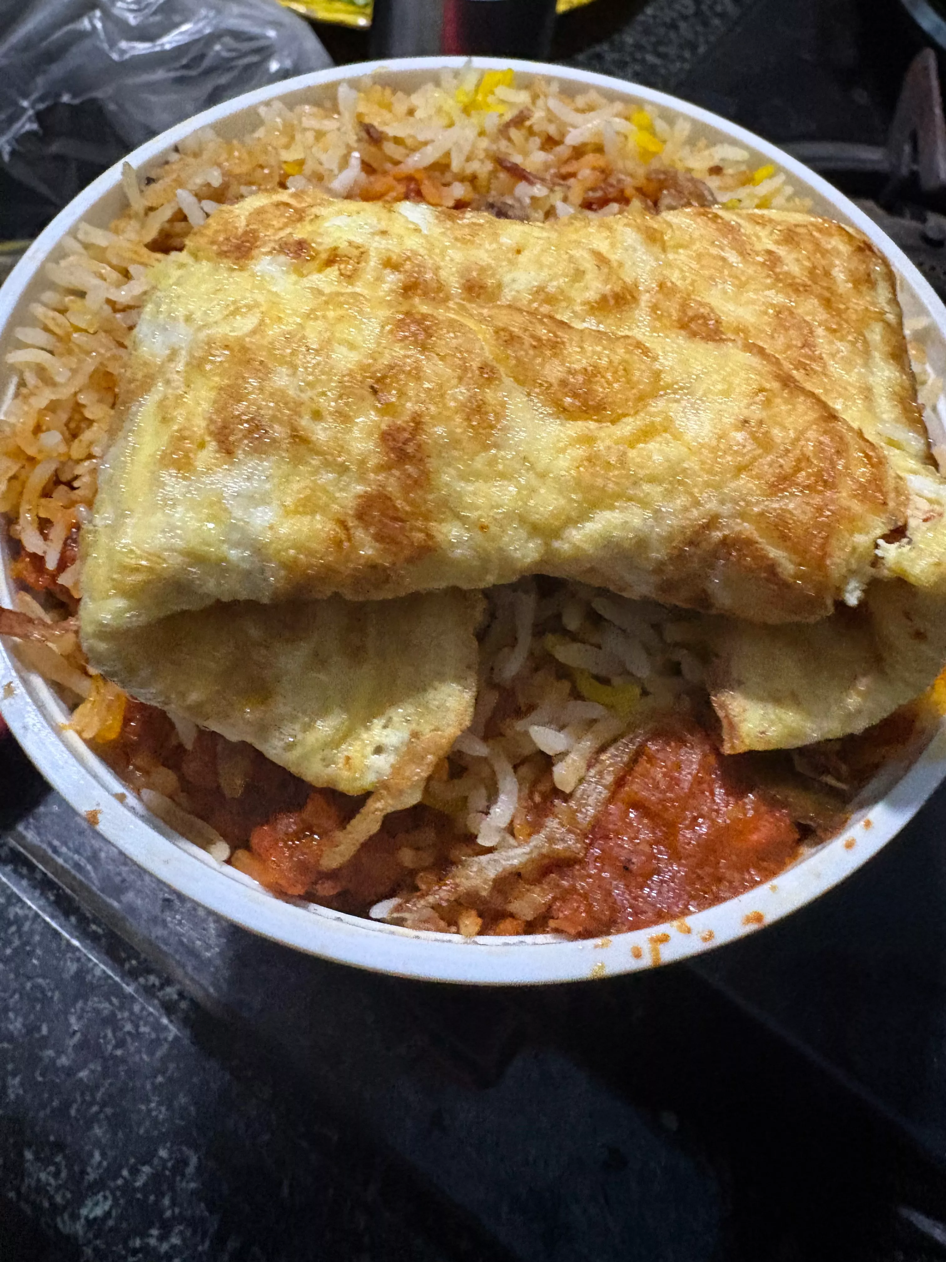 Omelette Biryani topped with a fluffy omelette, served in a bowl — Omelette Biryani in Nyra Hyderabad