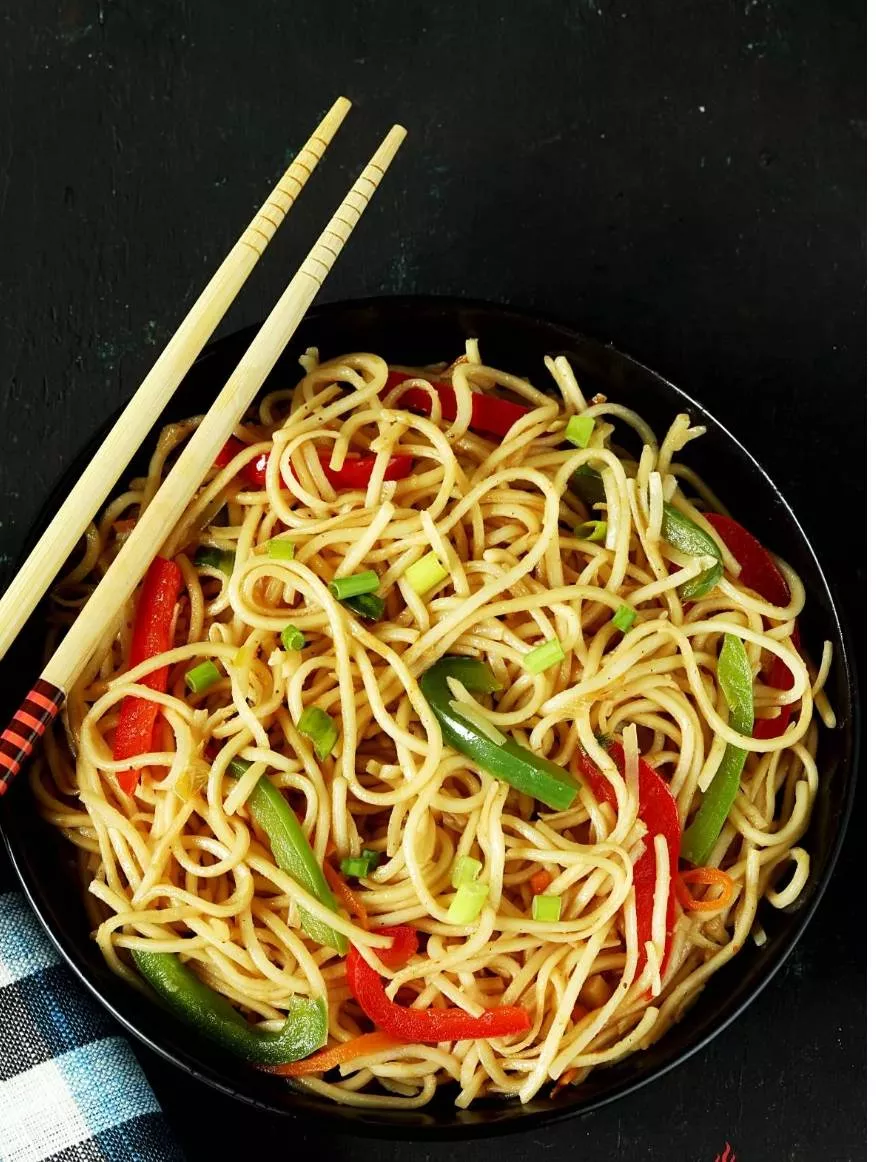 Delicious plate of Chinese Hakka noodles topped with colorful vegetables, served at SNAKKERS RESTAURANT in Jalandhar.