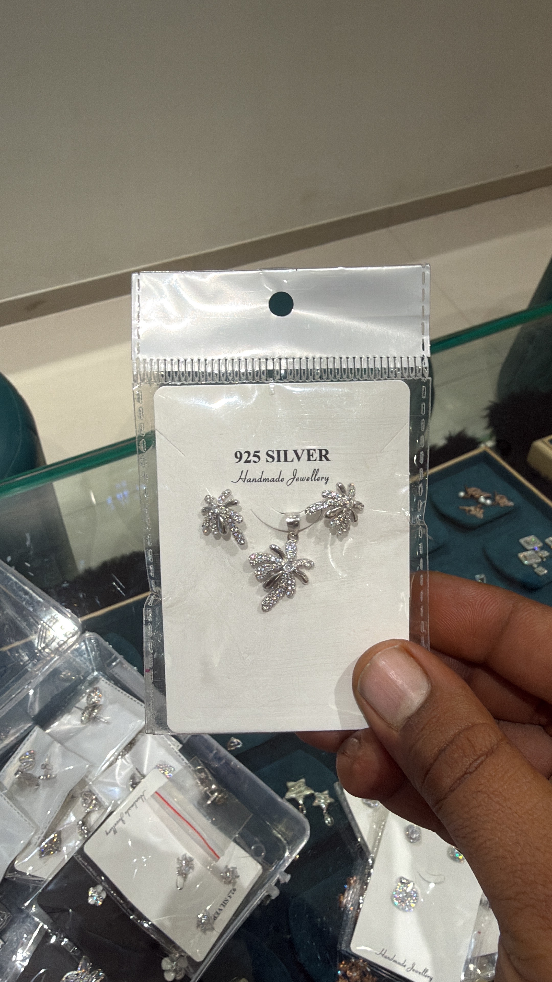 Elegant 925 silver jewelry set featuring a pendant and earrings with floral motifs, showcased in Rajkot
