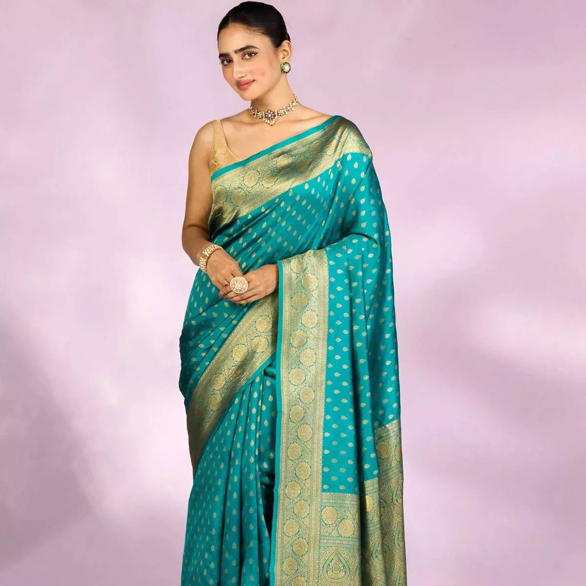 Elegant Teal Blue Banarasi Silk Saree with golden zari patterns displayed in ARMORI, showcasing its luxurious texture and vib