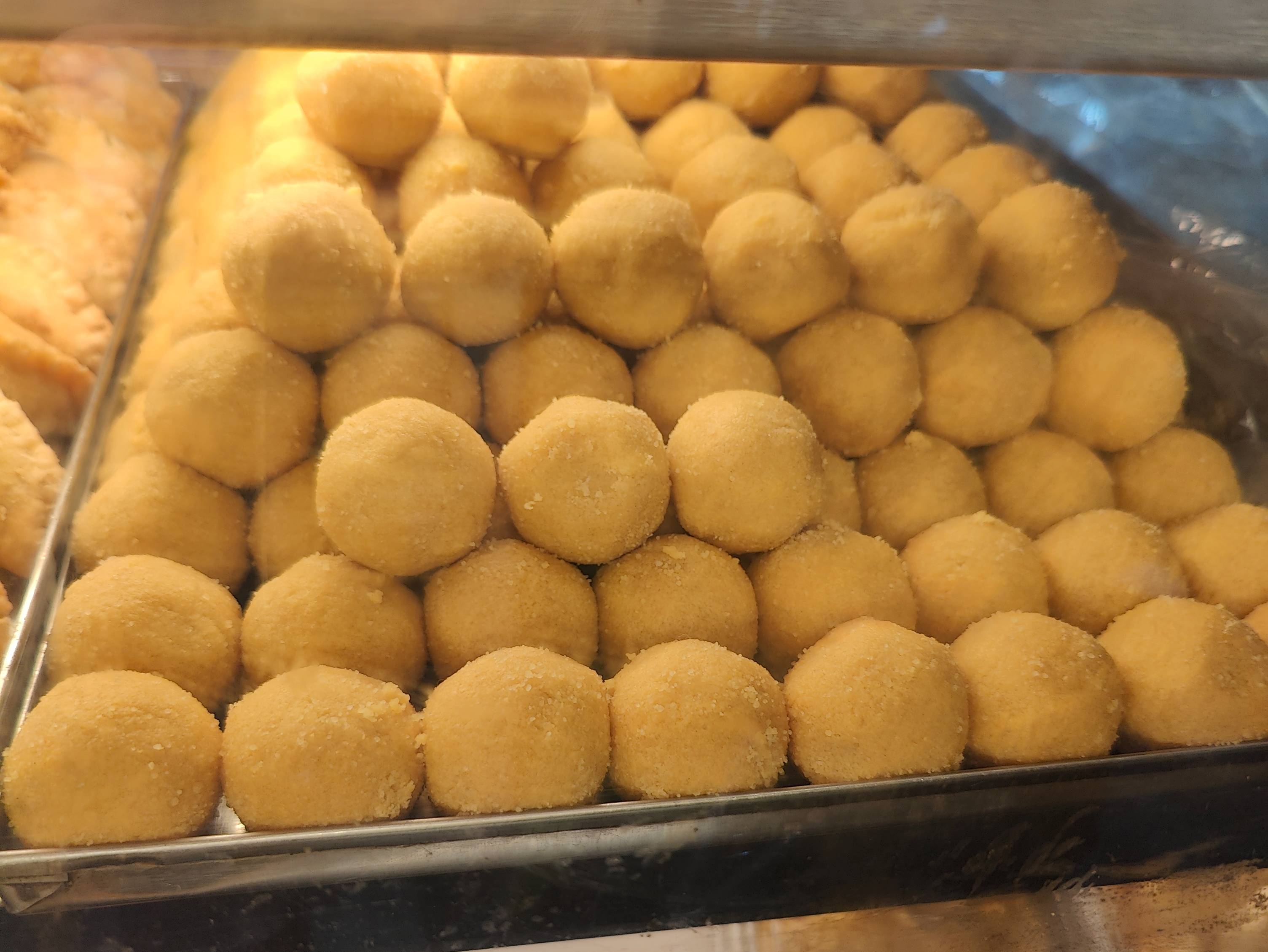 Delicious round Laddus made with traditional ingredients displayed elegantly in a bowl at SHREE SWEETS AND FAST FOODS in Gaut
