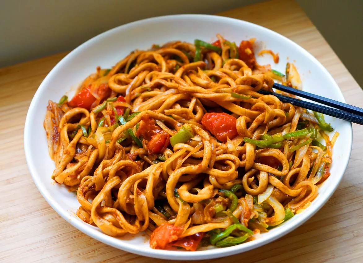 Delicious spicy vegetarian Hakka noodles served in a bowl with fresh vegetables, from AREA 30 in Imphal, garnished for presen