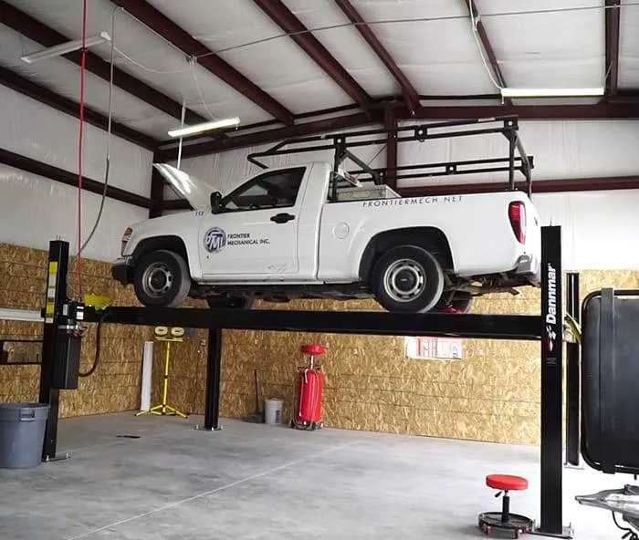 Portable four-post car lift designed for garages, featuring a sturdy structure and easy controls, perfect for vehicle mainten