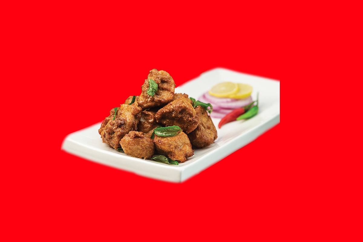 Crispy Chicken Pakora served on a plate with a side of chutney in Hyderabad, showcasing its golden-brown color and crunchines