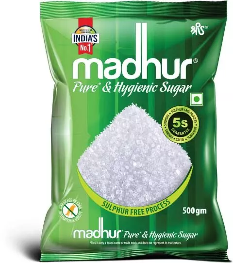 Premium Madhur Sugar granules in a clear packaging, showcasing its fine texture and purity, available in Digboi.