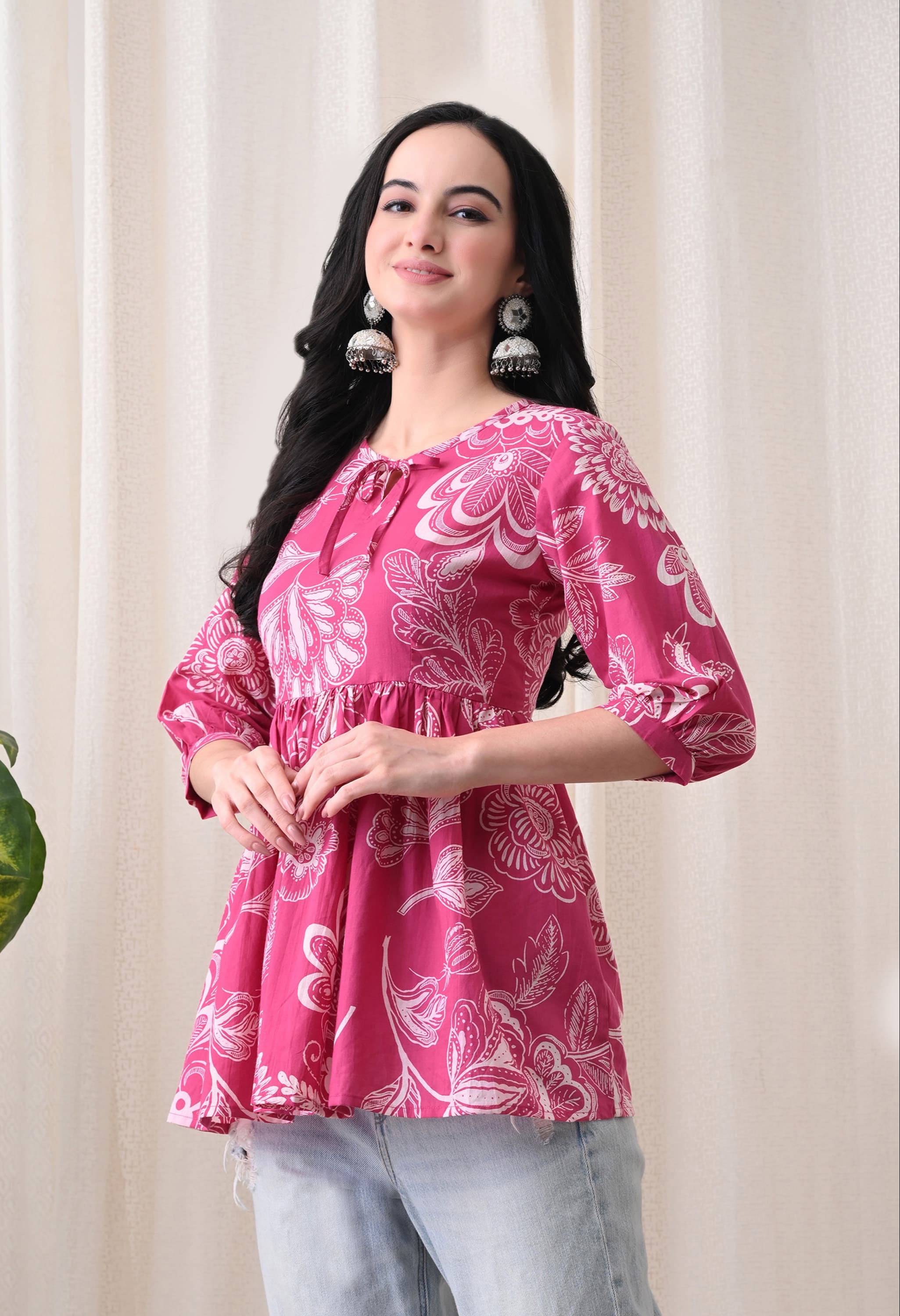 Vibrant pink floral cotton peplum top hanging on display in Jaipur, showcasing its elegant design and breathable fabric. - Image 3