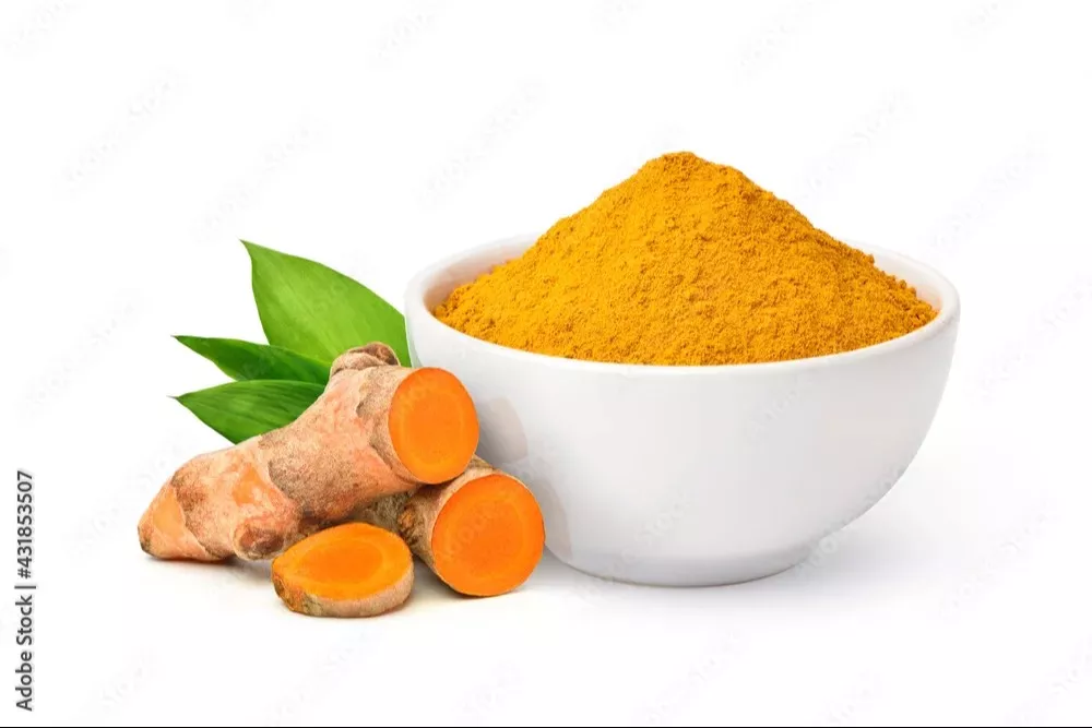 Organic turmeric powder in a bowl with a golden hue, displayed on a wooden surface, showcasing its fine texture — Organic Tur