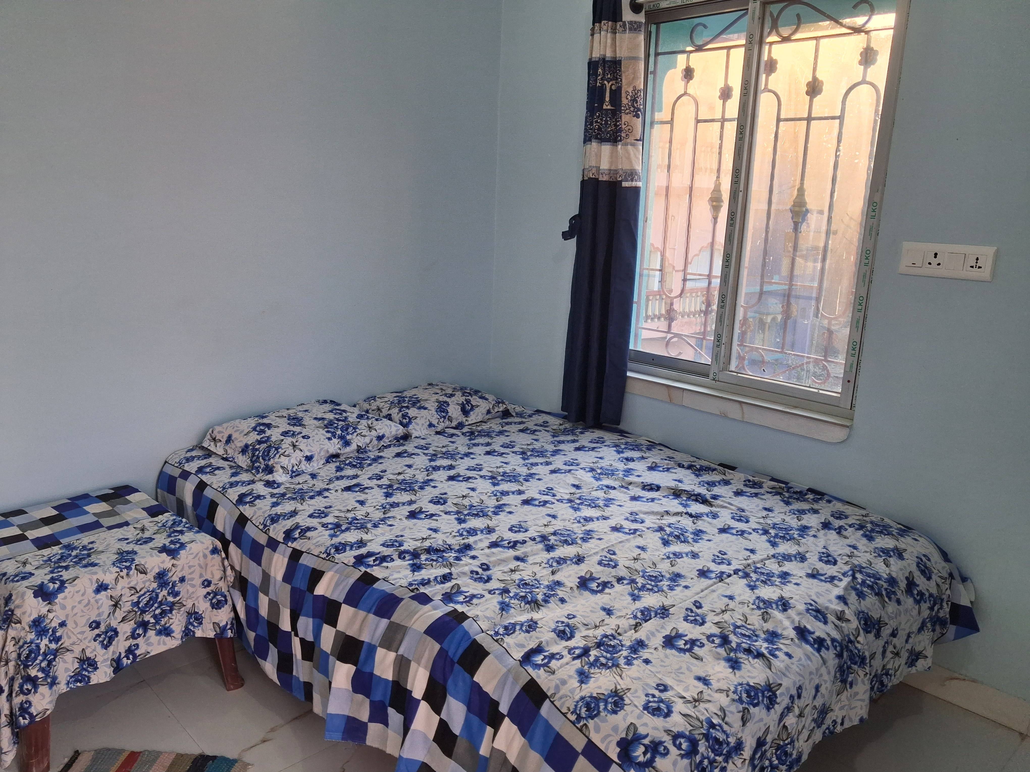 Elegant Couple Bedroom with a floral queen-sized cotton bedsheet and matching pillow covers, featuring a balcony view, locate