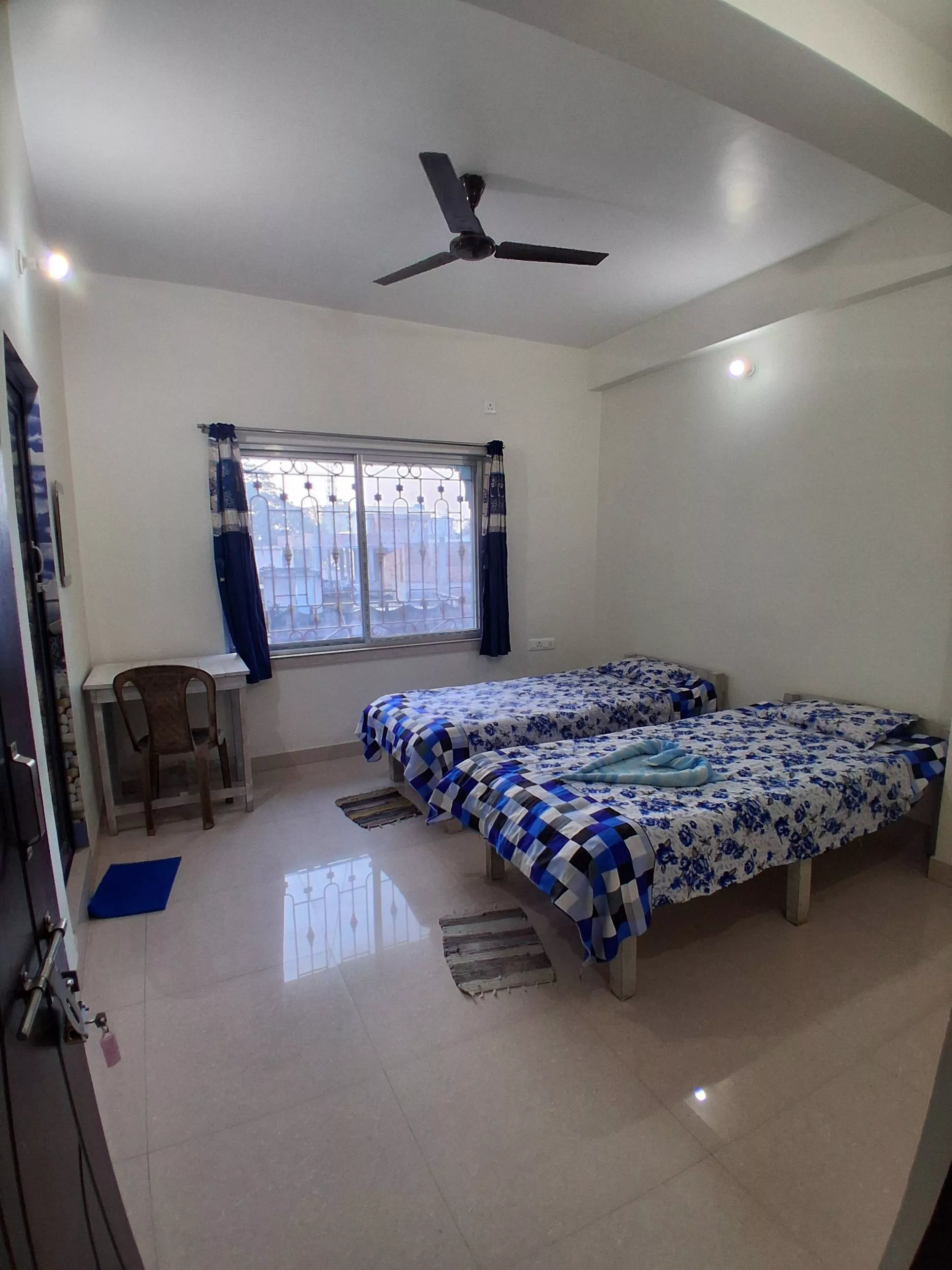 Elegant double bed room with blue floral bedsheet set in NABADWIP, designed for 2 adults and 1 child, featuring an attached b - Image 1