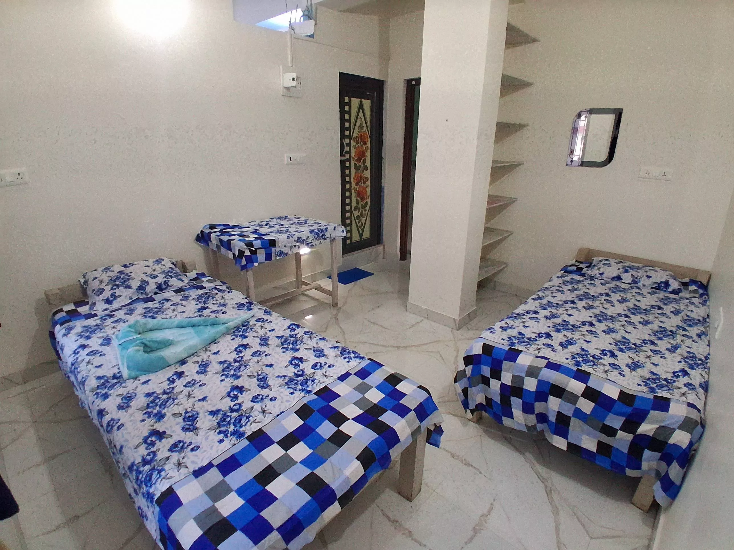 Elegant double bed room with blue floral bedsheet set in NABADWIP, designed for 2 adults and 1 child, featuring an attached b - Image 2
