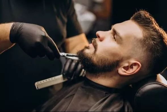 Expert barber trimming a stylish beard at BLUSH in Ambala City, showcasing precision and professionalism in grooming. - Image 1