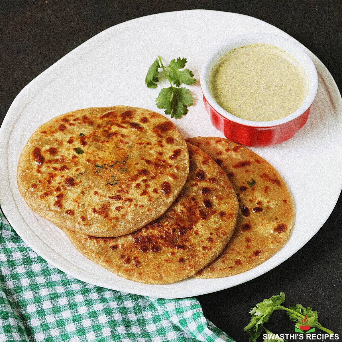 Deliciously stuffed Mooli Parantha served hot, showcasing the golden-brown color and flaky texture, from SIZZLING TAWAZ AND T