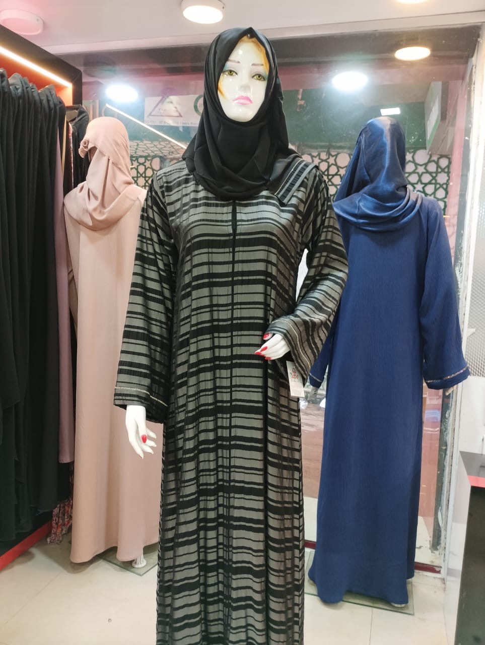 Elegant Black Abaya displayed on a mannequin in Mangalore, featuring silver accents for a sophisticated look.