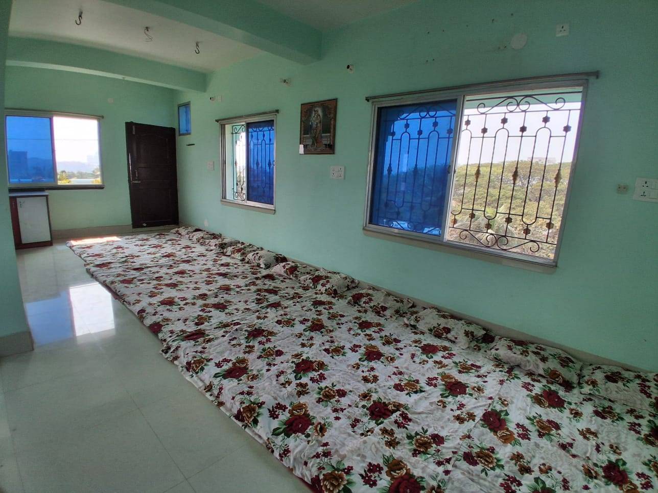 Spacious 20-Person Dormitory Room in Nabadwip with floor mattresses and modern amenities for group stays. - Image 1