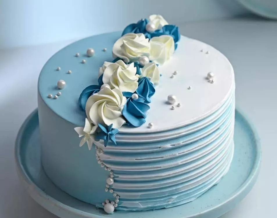 Elegant blue and white floral cake with creamy decor, perfect for celebrations, available at SHIV KARYANA STORE in GARHSHANKA