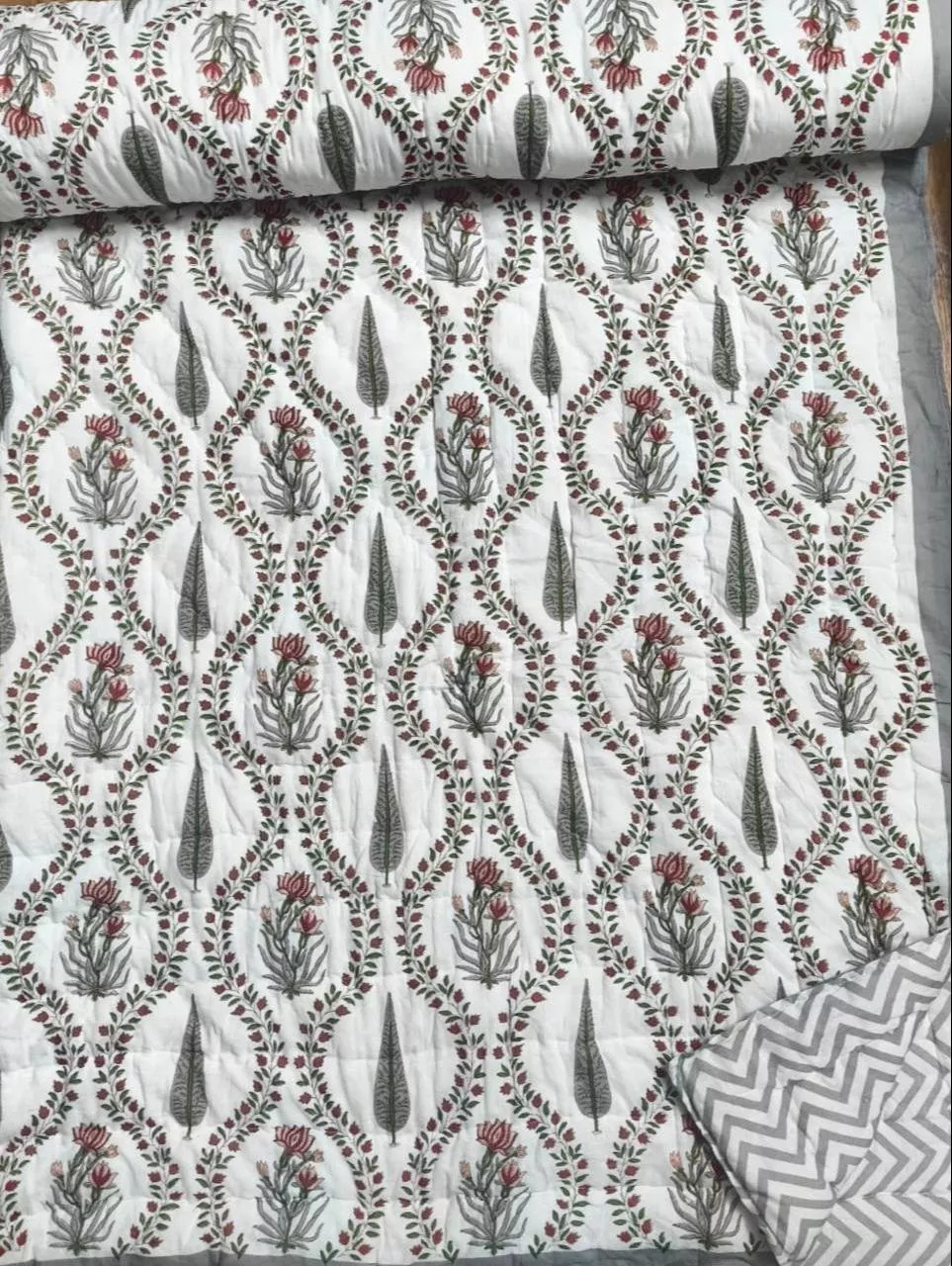 Luxurious Jaipur Quilt Double-Bed Quilt with reversible floral patterns displayed on a bed in MANSAROVAR, showcasing its intr