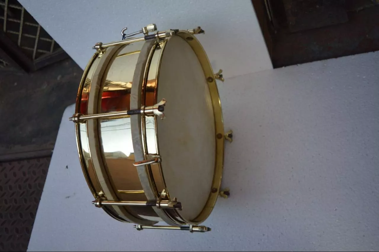 BRASS SIDE DRUM 14'' with polished brass finish and adjustable drumheads, displayed in a music studio in Meerut.
