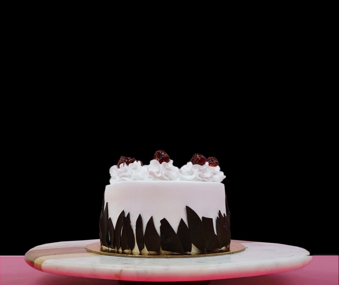 Decadent Black Forest luxe cake with layers of chocolate sponge, whipped cream, and cherries, beautifully presented in Bangal