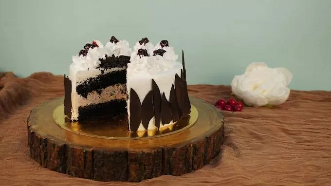 Decadent Black Forest luxe cake with layers of chocolate sponge, whipped cream, and cherries, beautifully presented in Bangal - Image 1