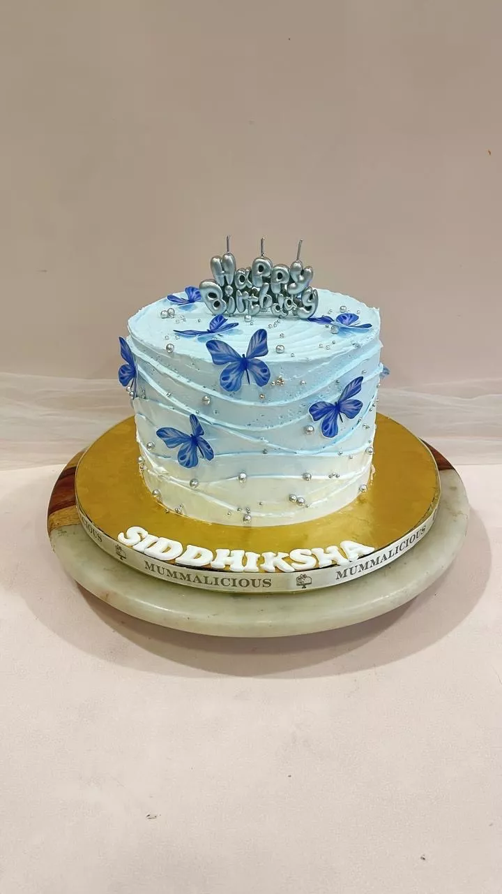 Beautifully decorated Blue Butterfly Birthday Cake featuring edible butterflies and pearls, available at MUMMALICIOUS in Bang