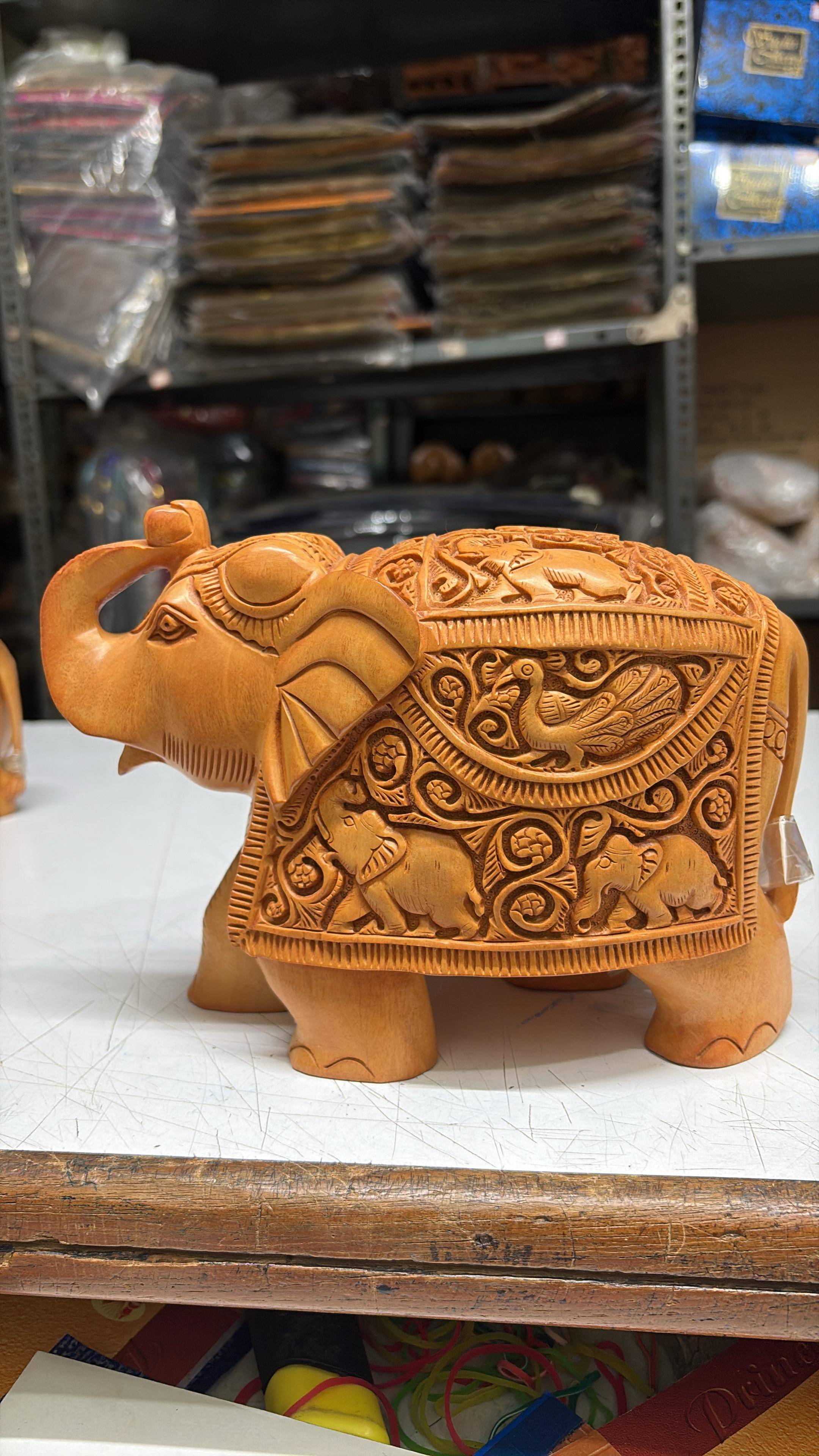 CAVERY COTTAGE EMPORIUM - Wood Carving Master Carving Trunk Up Elephant in Bangalore in BANGALORE