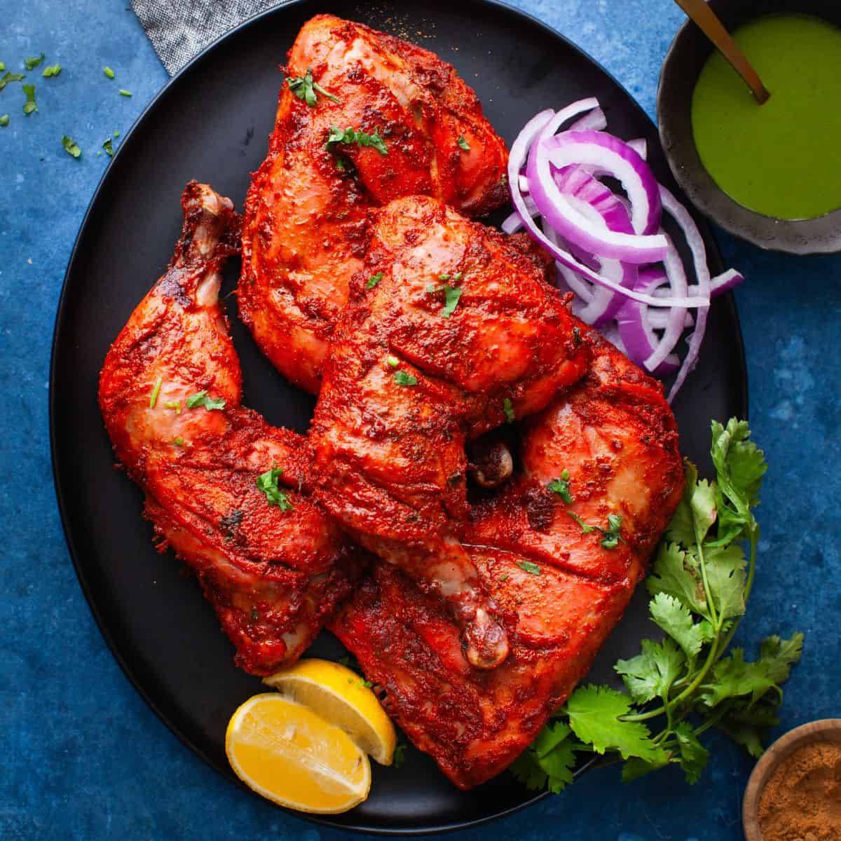 Full Tandoori chicken grilled to perfection with spices, served on a plate at BALAJI GRAND in Sindhanour